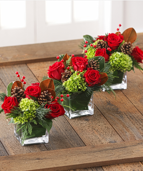 The Christmas Cottage Centerpieces feature southern magnolia, hydrangea, red roses, pine and scented cedars. 