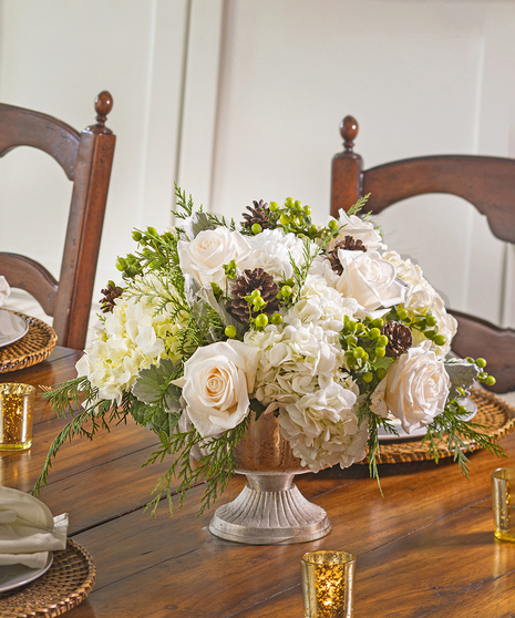 The Snowdrift Bouquet features invory roses in a cloud of white hydrangea and winter foliage.