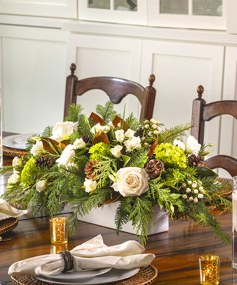 Winter Traditions Centerpiece featuring winter foliage and white and cream premium flowers