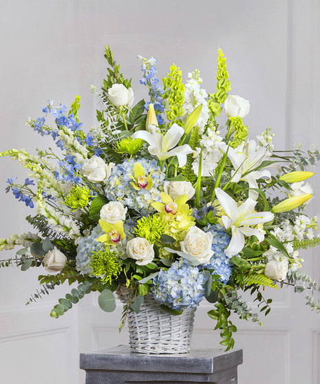 Blue & White Garden Sympathy Basket featuring hydrangea, delphinium, roses, stock and lush foliage