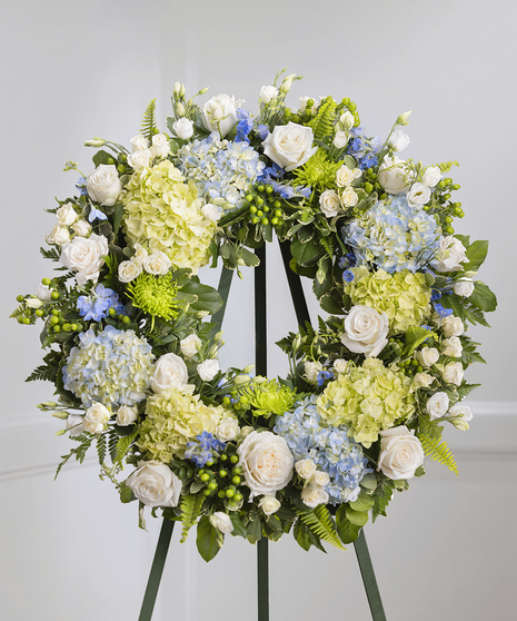 Blue and White Garden Floral Wreath on a standing easel featuring hydrangea, roses, delphinium and lush foliage