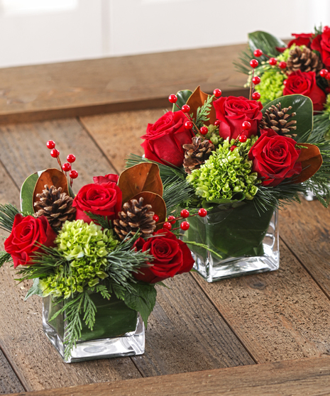 The Christmas Cottage Centerpieces feature southern magnolia, hydrangea, red roses, pine and scented cedars. 