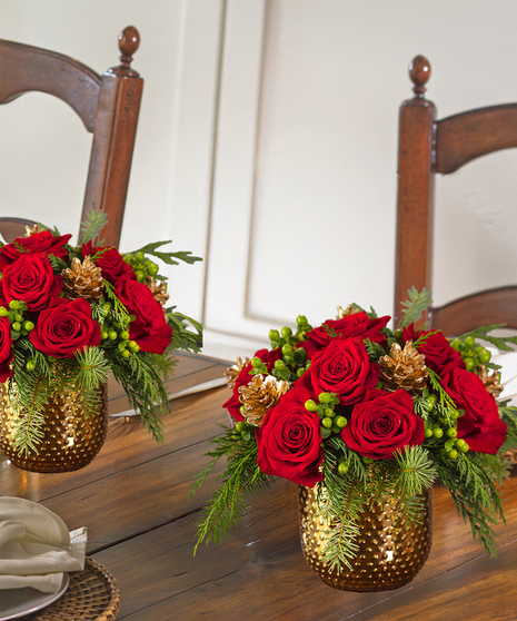 The Christmas Delight Bouquet features red roses, glass ornaments, and snow tipped cones in scented christmas greens.