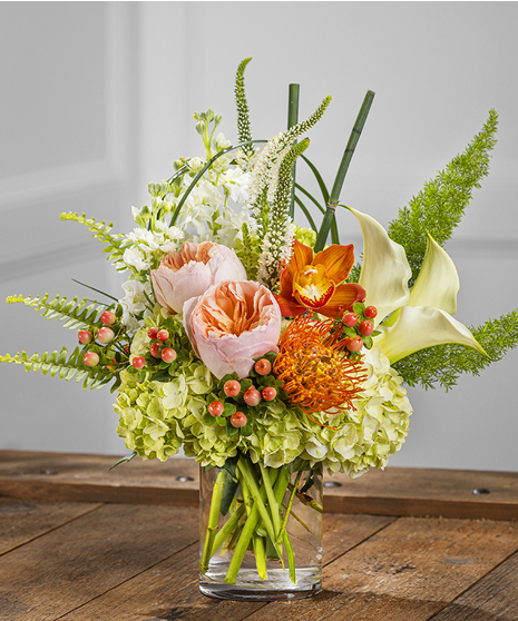 Peaches & Cream features kiwi hydrangea, calla lily, stock, veronica and garden roses roses in a clear glass vase.