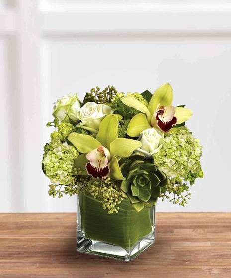 green arrangement with orchids, roses, hydrangeas, and more