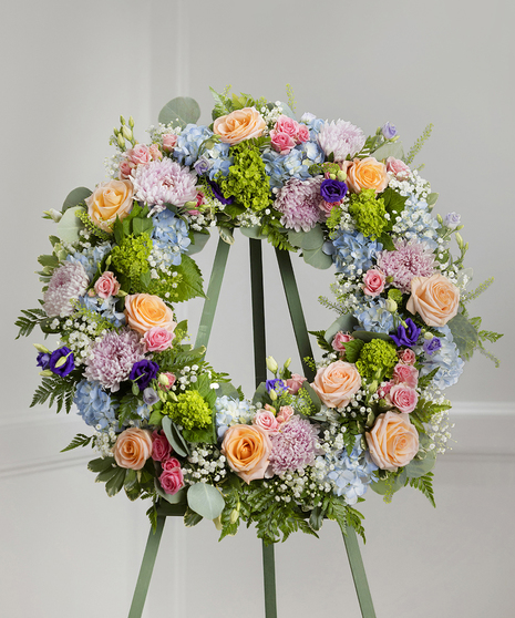 Elegant Pastel Garden Sympathy Wreath featuring pastel farm-fresh flowers on a standing easel