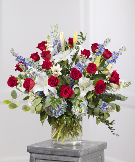 Patriot Garden Sympathy Vase featuring blue hydrangea, red roses and white garden stock