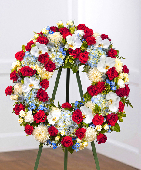 Patriot Garden Sympathy Wreath featuring hydrangea, roses, delphinium and foliage on a standing easel