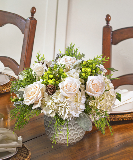 The Snowdrift Bouquet features invory roses in a cloud of white hydrangea and winter foliage.